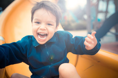 Portrait of smiling boy on slide