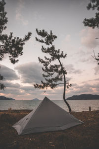 View of tent on field against sky during sunset