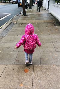 Rear view of girl walking on footpath