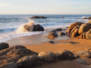 Rocks on beach against sky