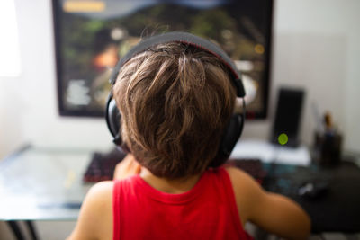 Rear view of boy sitting at home