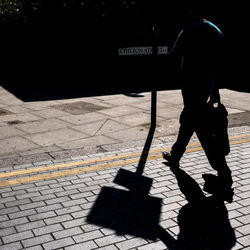 Rear view of man walking on footpath