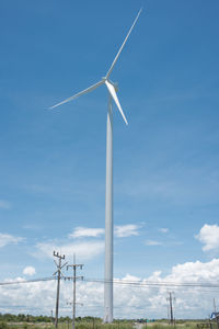 Low angle view of windmill against blue sky