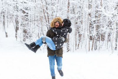 Portrait of smiling man standing in snow