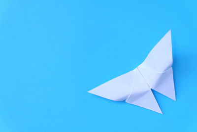 High angle view of paper boat over blue background