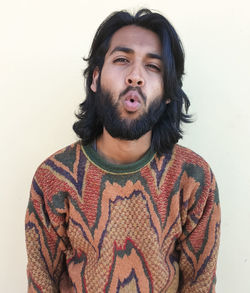 Portrait of young man standing against white background