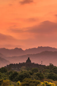 Scenic view of mountains against orange sky