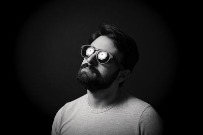 Portrait of young man against black background