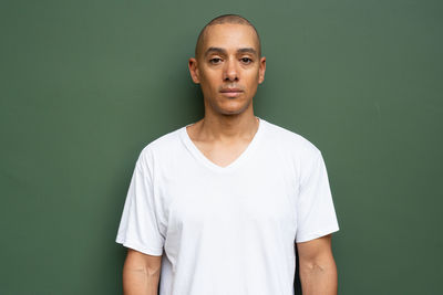 Portrait of young man standing against gray background