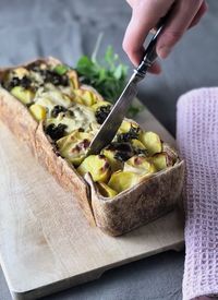 Midsection of man holding fruit on cutting board