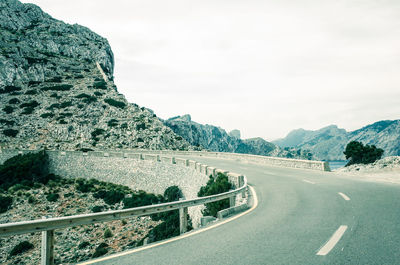 Road by mountain against sky