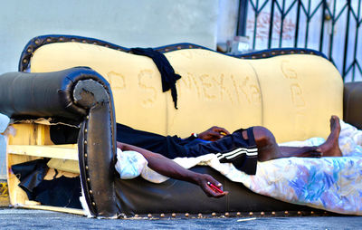 Rear view of man lying on street in city