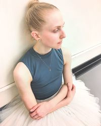 Low section of girl sitting on wall at home