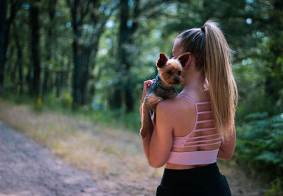 Rear view of woman with dog outdoors