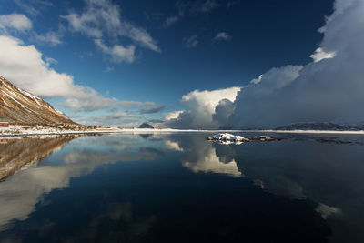 Scenic view of lake by mountains against sky