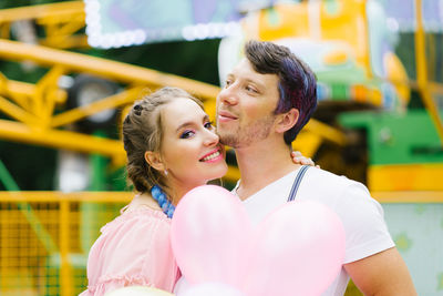 Happy couple in love is having fun at an amusement park in the summer. valentine's day