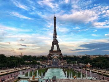 Eiffel tower in city against blue sky during sunset