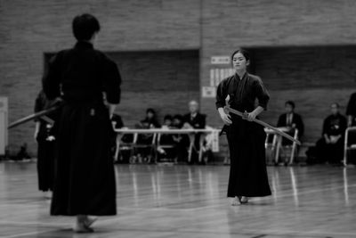 Full length of man and woman practicing kendo