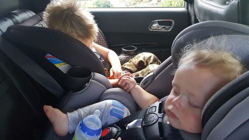 Siblings sleeping in car