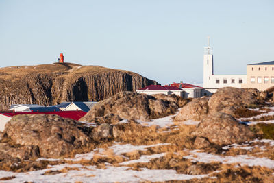 Building by rocks against clear sky