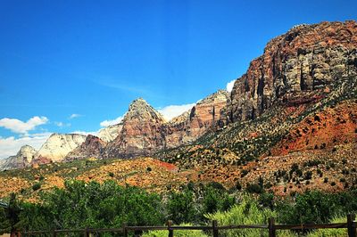 Low angle view of rocky mountain against blue sky