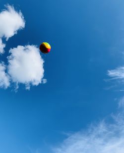 Low angle view of balloons against blue sky