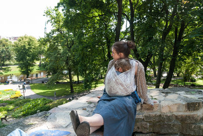 Woman standing on tree trunk