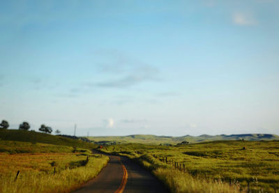 Empty road along countryside landscape