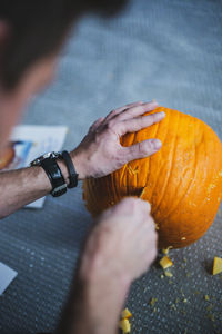 Midsection of man holding pumpkin