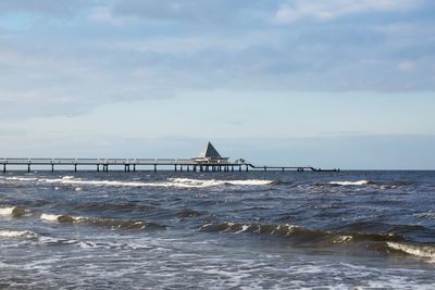 Scenic view of sea with pier against sky