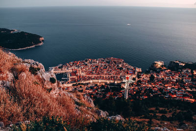 High angle view of townscape by sea against sky