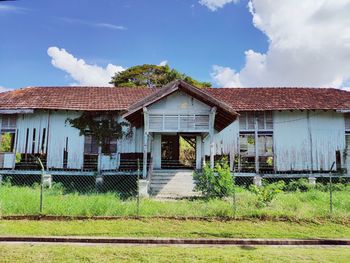 Abandoned house on field against sky