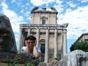 Portrait of young woman against building