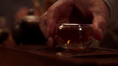 Close-up of man drinking glass on table