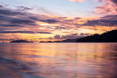 Scenic view of sea against dramatic sky during sunset