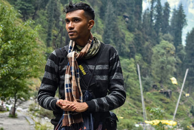 Young man looking away in forest