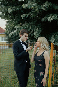 Side view of young couple holding plants