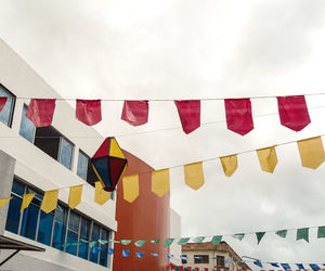 Low angle view of flags hanging against building