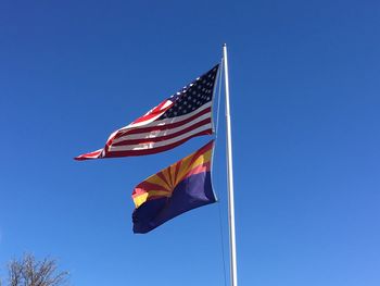 Low angle view of flag against blue sky