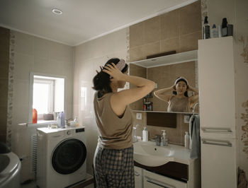 Asian beauty starts her morning routine with a reflection in the bathroom mirror