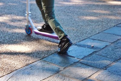 Low section of child using a scooter