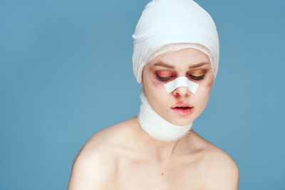 Young woman wearing bandage against colored background