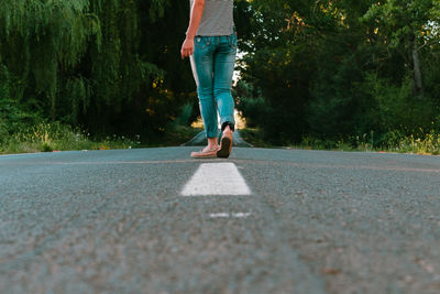 Low section of woman walking on road