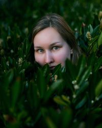 Portrait of beautiful young woman by plants