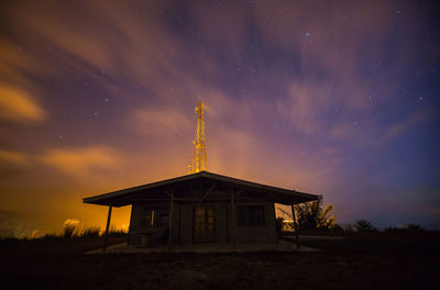 Traditional building on field against sky at night