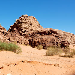 Rock formations in desert against clear blue sky