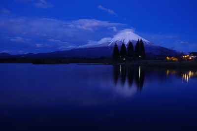 Scenic view of lake against blue sky at dusk