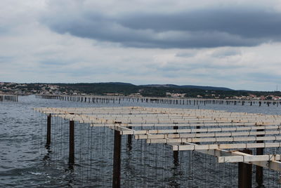 Pier on sea against sky in city