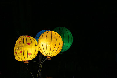 Low angle view of illuminated lantern against black background