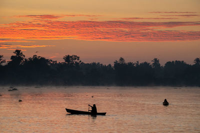 Silhouette boat in sea against sky during sunset